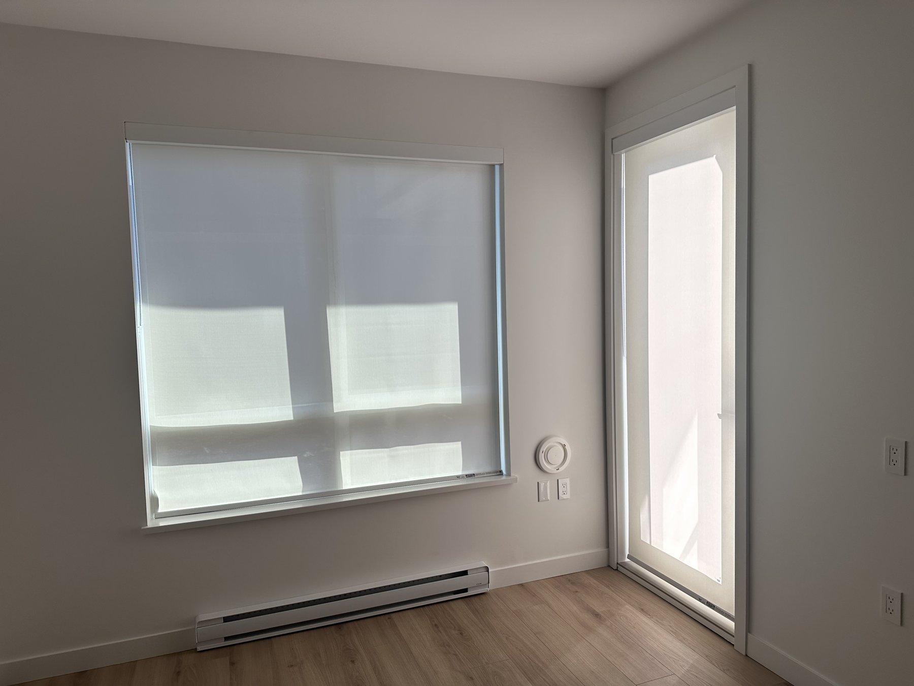 Roller shades on a bedroom window and patio door